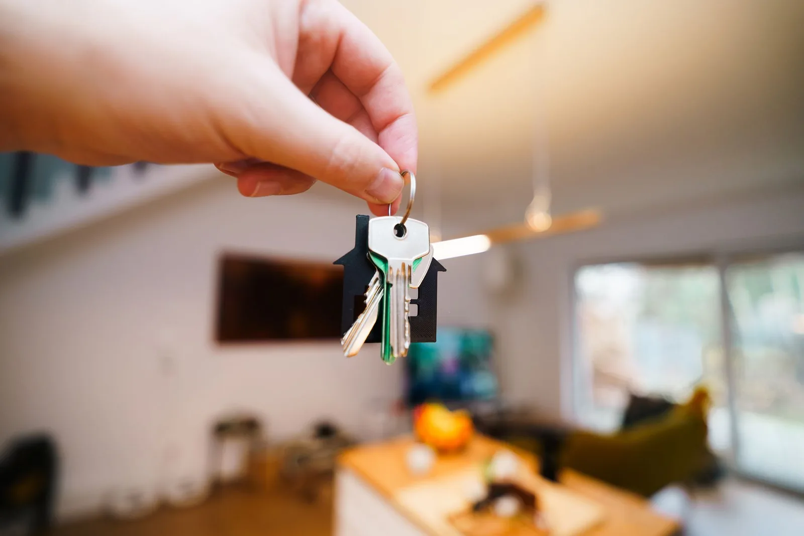 Una mano entrega las llaves de una vivienda en un salón luminoso